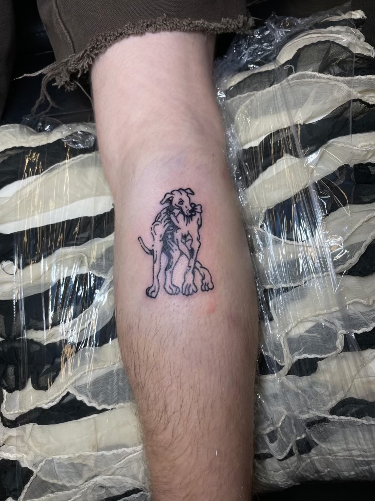 Fine line illustrative dog calf tattoo by Emma Bray
