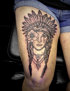 Native headdress portrait black and grey thigh tattoo by Eric Bryant