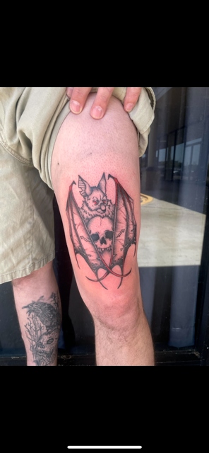 Black and grey bat skull crest thigh tattoo by Taylor Brown