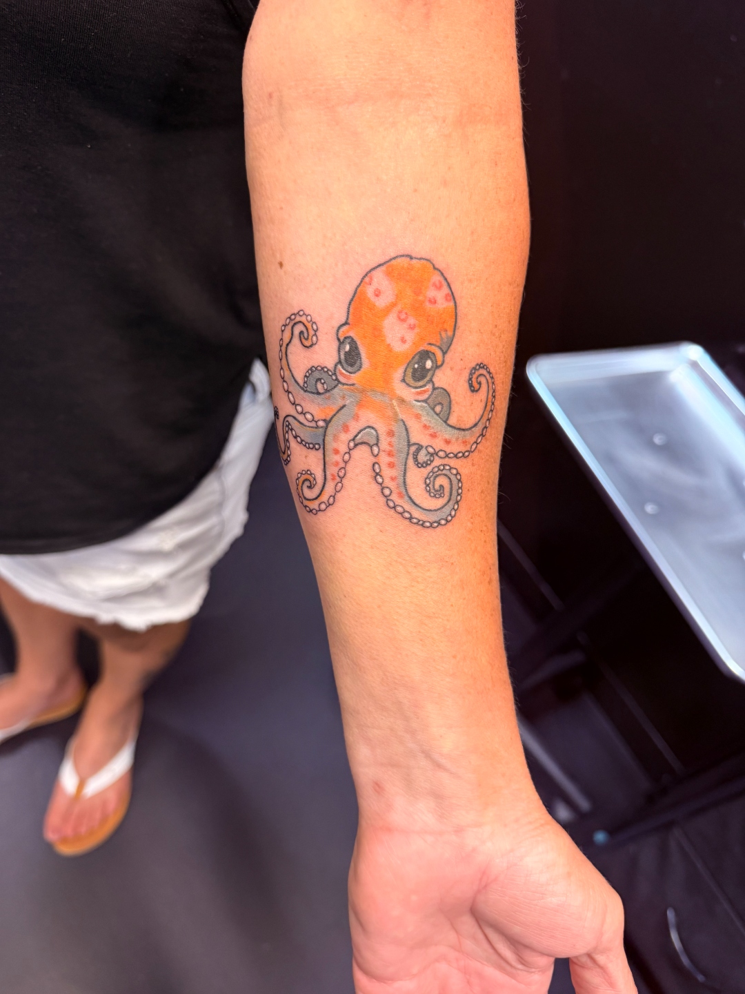 Neo-traditional orange octopus forearm tattoo by Wesley Herring
